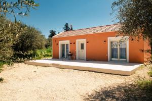 a small orange house with a patio at Petit Palace in Lefkimmi