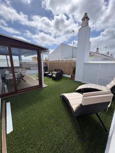 a patio with a lawn with a couch on it at Ático en Barbate in Barbate