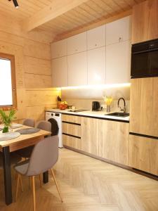 a kitchen with wooden cabinets and a table with chairs at Potokowe Zacisze in Zakopane