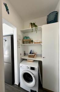 a laundry room with a washing machine and a refrigerator at Apartamento Maravía La Restinga in La Restinga