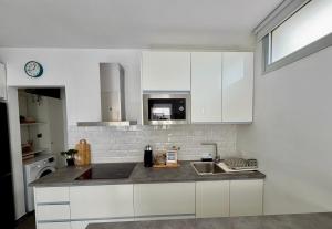 a kitchen with white cabinets and a sink at Apartamento Maravía La Restinga in La Restinga