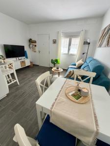 a living room with a table and a blue couch at Apartamento Maravía La Restinga in La Restinga