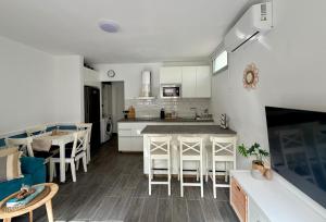 a kitchen with white cabinets and a table and chairs at Apartamento Maravía La Restinga in La Restinga +6 photos