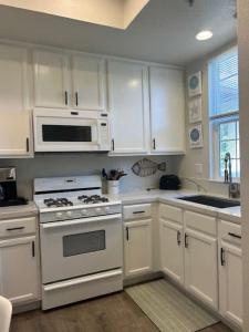 a kitchen with white cabinets and a stove and microwave at Tranquil Terrace in Oceano