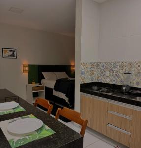 a kitchen and a bedroom with a bed and a table at Loft Marinês in Campina Grande