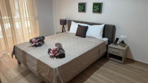 a bedroom with a large bed with two dolls on it at imvros home luxury in Alexandroupoli