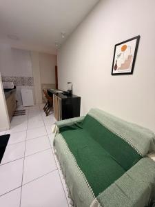 a bedroom with a green blanket on the wall at Loft Marinês in Campina Grande
