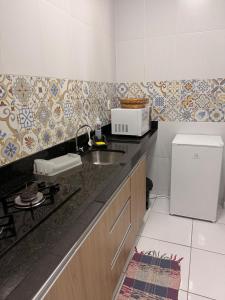 a small kitchen with a sink and a microwave at Loft Marinês in Campina Grande