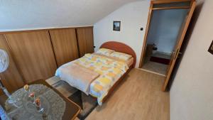 a small bedroom with a bed and a mirror at Stan na dan Cazin in Cazin