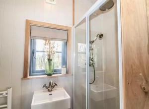 a bathroom with a sink and a shower and a mirror at Farm view hall in Harrogate +17 photos