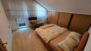 a small bedroom with a bed and a table at Stan na dan Cazin in Cazin +6 photos