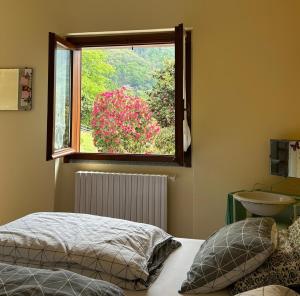 a bedroom with a window and a bed and a sink at B&B Il Picchio in Mergozzo