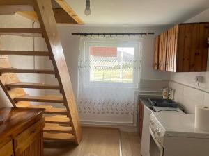 a kitchen with a staircase leading up to a window at Petrovica in Aluga +20 photos