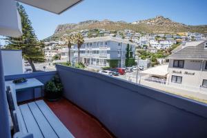 a balcony with a bench and a view of a city at Modern Seaside Apartment in Fish Hoek