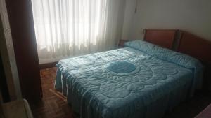 a bedroom with a bed with a blue comforter at Rooms Melide in Melide