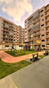 a park with a playground with benches and buildings at Aracaju Apartamento 2 Quartos Proximo A Orla de Atalaia Praia de Aruana Aeroporto Shopping Sul in Aracaju