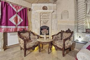 a living room with two chairs and a fireplace at Tatlı Kaya Cave Otel in Ürgüp