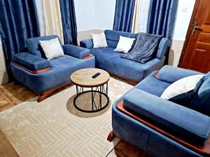 a living room with two blue couches and a table at Cosmic homes Ruiru Kimbo in Ruiru