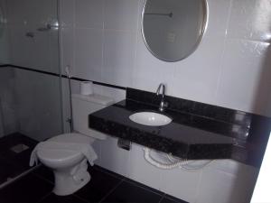 a bathroom with a sink and a toilet and a mirror at Majestic Hotel in Juiz de Fora