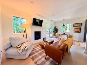 a living room with two chairs and a fireplace at Charming Private Cottage in Ojai in Ojai