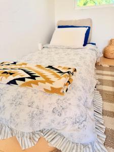 a bed with orange and white blankets and pillows at Charming Private Cottage in Ojai in Ojai