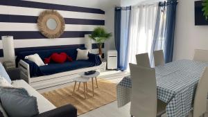 a living room with a blue couch and a table at Blue Beach Home with Terrace in Albufeira