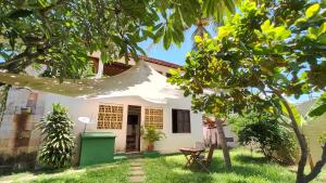 a white house with a tent in the yard at Casa Mandacaru Pousada in Cumbuco