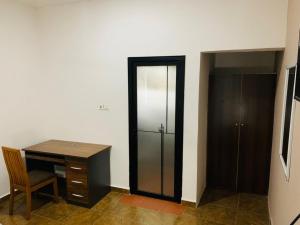a room with a desk and a closet and a cabinet at Water House Lodge in Apenkwa