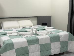 a bed with a green and white blanket on it at Mangro villa in Mayyanād