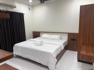 a bedroom with a bed with a stuffed animal on it at Mangro villa in Mayyanād