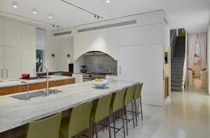 a kitchen with a large counter with yellow bar stools at כוכב קיסר in Caesarea