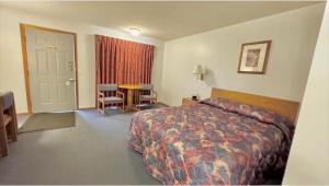 a hotel room with a bed and a table and chairs at North Winds Lodge LLC in Bowman