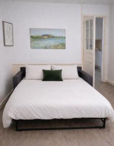 a large bed in a bedroom with a white bedspread at Gîte Le Repos de Merlin - Paimpont, Forêt de Brocéliande in Paimpont