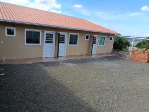 a house with white doors and a gravel driveway at Pousada Paraiso in Telêmaco Borba
