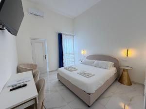 a bedroom with a bed and a table and a desk at Ippolita Palace LUXURY ROOMS in Otranto
