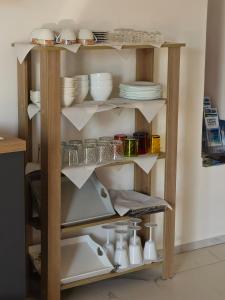 a shelf with plates and dishes on it at B&B Kasia in Palmadula +25 photos