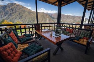 a room with couches and a table with a laptop on it at Vache Hotel in Kazbegi