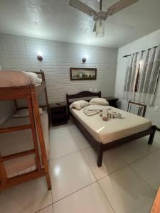 a bedroom with a bed and a ladder and a bunk bed at Pousada Vento Leste in Cabo Frio