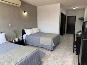 a hotel room with two beds and a television at Hotel Plaza in Tuxpan de Rodríguez Cano