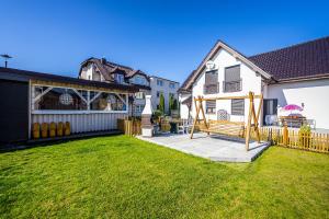 a backyard with a wooden bench and a house at Fajne Domki in Jastarnia