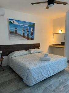 a bedroom with a bed and a painting on the wall at Playa Arena in Progreso +66 photos