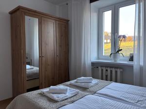 a white bedroom with a bed and a window at Apartament Babie Lato in Szczawnica