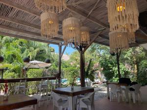 a restaurant with tables and chairs and chandeliers at Kawabonga in Palomino +27 photos