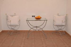 a table with two chairs and a bowl of fruit on it at Residence 33 vèrte in Guelmim +2 photos