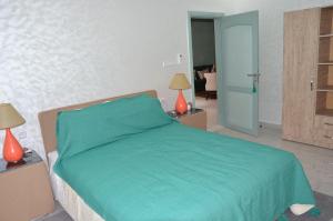 a bedroom with a green bed with two lamps at Residence 33 vèrte in Guelmim
