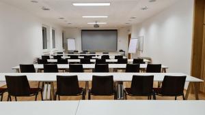 a conference room with a white table and chairs at Hotel Tyrolis in Zirl