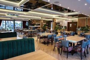 a restaurant with wooden tables and chairs and tablesktop at STELLA Resort & SPA in Władysławowo