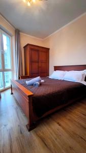 a bedroom with a large bed with a wooden headboard at Dawn Park Deluxe 3 floor in Sunny Beach