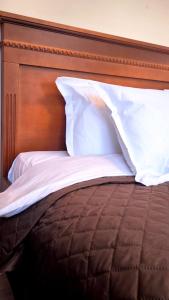 a bed with a wooden headboard and white pillows at Dawn Park Deluxe 3 floor in Sunny Beach +27 photos