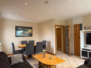 a living room with a table and a dining room at Bungalow, Dornumersiel in Dornumersiel +9 photos